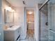 Bathroom featuring a vanity, a tile shower, and an open door to a laundry room at 5743 Cherrycrest Ln, Charlotte, NC 28217
