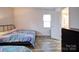 Bedroom with vinyl floors, a comfortable bed, and natural light from a window at 5743 Cherrycrest Ln, Charlotte, NC 28217