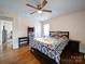 Bright bedroom featuring hardwood floors, ceiling fan, and a patterned comforter at 5743 Cherrycrest Ln, Charlotte, NC 28217
