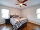 Bright bedroom featuring hardwood floors, ceiling fan, and a patterned comforter at 5743 Cherrycrest Ln, Charlotte, NC 28217