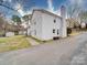 Exterior view of the white brick house with a chimney, a shed, and a large driveway at 5743 Cherrycrest Ln, Charlotte, NC 28217
