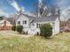 An eye-level outdoor shot of a white brick home with a white porch and trimmed bushes at 5743 Cherrycrest Ln, Charlotte, NC 28217