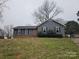 Charming single-story home featuring gray siding, black shutters, and a red front door at 5815 Katrine Ct, Charlotte, NC 28208