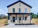 Charming brick home boasts a welcoming front porch, complemented by dark blue accents and meticulous landscaping at 588 Washington Ln, Albemarle, NC 28001