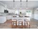 Modern kitchen featuring white cabinets, granite countertops, and a central island with bar seating and stylish pendant lights at 588 Washington Ln, Albemarle, NC 28001