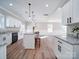 Open-concept kitchen and living area with kitchen island, bar seating, and hardwood floors at 588 Washington Ln, Albemarle, NC 28001