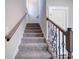 Carpeted staircase with decorative iron railings and wooden accents, offering a stylish transition between floors at 588 Washington Ln, Albemarle, NC 28001