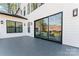 Outdoor patio featuring dark grey tiles, modern exterior lighting, and sliding glass doors to living area at 621 Poindexter Dr, Charlotte, NC 28209