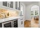 Beautiful Butler's pantry with custom cabinets, wine cooler, and brick backsplash detail at 621 Poindexter Dr, Charlotte, NC 28209