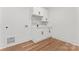 Functional laundry room features stylish cabinets, a sink, and a brick backsplash at 621 Poindexter Dr, Charlotte, NC 28209