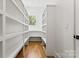Spacious walk-in pantry with custom shelving providing ample storage space at 621 Poindexter Dr, Charlotte, NC 28209