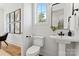 Bright powder room featuring modern fixtures, pedestal sink, and stylish wall decor at 621 Poindexter Dr, Charlotte, NC 28209