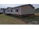 Side view of a well-maintained home, showing the vinyl siding and brick foundation at 7051 Maple Glen Dr, Catawba, NC 28609