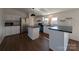 Modern kitchen with white cabinets, a central island, stainless steel appliances, and wood floors at 7051 Maple Glen Dr, Catawba, NC 28609