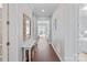 Elegant hallway with hardwood floors, a decorative mirror, and views of the living spaces at 7127 Hanging Rock Ct, Denver, NC 28037