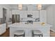 Bright kitchen features white cabinets, stainless steel appliances and a central island with bar stool seating at 7127 Hanging Rock Ct, Denver, NC 28037