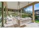 Covered patio features a swing, seating area, and a view of the backyard with mature trees at 7127 Hanging Rock Ct, Denver, NC 28037