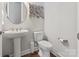 Stylish powder room with pedestal sink, round mirror, and modern fixtures at 7127 Hanging Rock Ct, Denver, NC 28037