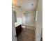 Bright bathroom with shower-tub combo, white tile surround, dark wood vanity, and tile floor at 7141 Adare Mews Rd, Charlotte, NC 28217