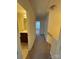 Hallway with neutral tones leading to a bathroom featuring a dark vanity and a bedroom with natural light at 7141 Adare Mews Rd, Charlotte, NC 28217