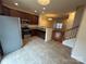 Modern kitchen with stainless steel appliances, sleek countertops, open to living room with hardwood floors and staircase at 7141 Adare Mews Rd, Charlotte, NC 28217