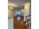Inviting living room featuring hardwood floors, a large window, and entry to a staircase at 7141 Adare Mews Rd, Charlotte, NC 28217