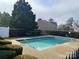 Community pool surrounded by lush greenery on a sunny day at 7141 Adare Mews Rd, Charlotte, NC 28217