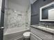 Bathroom boasts a granite countertop, a tub with modern marble-style tiling and a framed mirror at 7310 Yorkville Ct, Charlotte, NC 28273