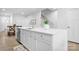 Bright kitchen island featuring a stainless steel sink, white cabinets and quartz countertops at 781 Hazel Way, Denver, NC 28037