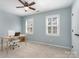 Bright bedroom features a ceiling fan, neutral carpet, and two windows that provide natural light at 8807 Thornbury Ln, Huntersville, NC 28078