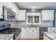 Well lit kitchen featuring a stove top, granite countertops, tile backsplash, and stainless steel appliances at 8807 Thornbury Ln, Huntersville, NC 28078