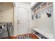 Mudroom area with a bench, coat hooks, overhead basket storage, and laundry machines at 8807 Thornbury Ln, Huntersville, NC 28078