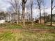Spacious backyard with mature trees, offering privacy and shade, enclosed by a chain link fence at 905 Kemper Cir, Rock Hill, SC 29732