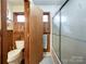 Bathroom with wooden paneling, toilet, and a glass-enclosed shower at 905 Kemper Cir, Rock Hill, SC 29732