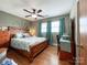 Light-filled bedroom with a wooden bed frame, wooden dresser and a fan with light fixture at 905 Kemper Cir, Rock Hill, SC 29732