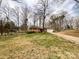 Charming brick home featuring an attached garage, spacious front yard, and long driveway surrounded by mature trees at 905 Kemper Cir, Rock Hill, SC 29732