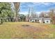 Wide shot of the backyard featuring an outdoor patio and mature trees at 914 Crestmere St, Charlotte, NC 28208