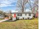 Charming single-story home with white brick exterior, bright red front door, and well-manicured landscaping at 914 Crestmere St, Charlotte, NC 28208