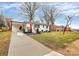 Picture of a white brick home with a carport, manicured landscaping, and a red front door at 914 Crestmere St, Charlotte, NC 28208