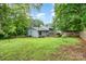 Exterior shot of a large backyard featuring a patio, lawn, trees, and privacy fencing at 917 Bobby Ln, Charlotte, NC 28211