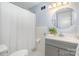 Cozy bathroom with white tile, gray vanity, and shower with white curtain at 917 Bobby Ln, Charlotte, NC 28211