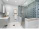 Updated bathroom featuring blue patterned tile shower and modern vanity at 917 Bobby Ln, Charlotte, NC 28211