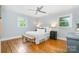 Light bedroom features hardwood floors, two windows, a ceiling fan and furnishings at 917 Bobby Ln, Charlotte, NC 28211