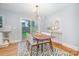 Sunlit dining area boasts modern light fixture, stylish rug, and sliding glass doors to the backyard at 917 Bobby Ln, Charlotte, NC 28211