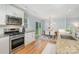 Open kitchen and dining area with stainless appliances, granite counters, and backyard view at 917 Bobby Ln, Charlotte, NC 28211