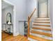 Staircase with hardwood steps, white risers, and a wooden handrail, leading to the upper level at 917 Bobby Ln, Charlotte, NC 28211