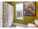 Neutral bathroom with shower, toilet, window, and decorative artwork at 10228 Seedling Ln, Charlotte, NC 28214