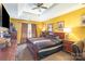Primary bedroom features a tray ceiling, a ceiling fan, and furnishings at 10228 Seedling Ln, Charlotte, NC 28214