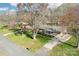 Aerial view of a brick home with a long driveway, mature trees and a well-maintained lawn at 108 Colonial Dr, Kings Mountain, NC 28086