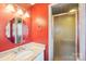 Bathroom featuring red walls, a pedestal sink, and a tiled shower at 108 Colonial Dr, Kings Mountain, NC 28086